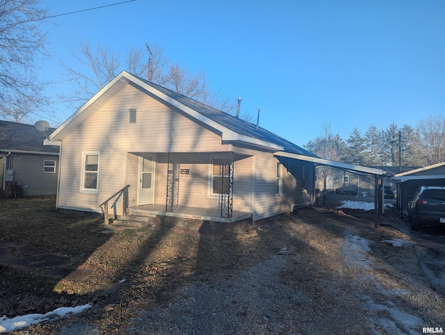 view of side of property featuring a carport and covered porch