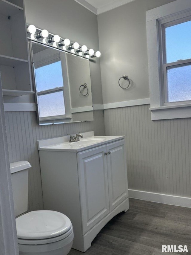 bathroom featuring vanity, hardwood / wood-style floors, wood walls, and toilet