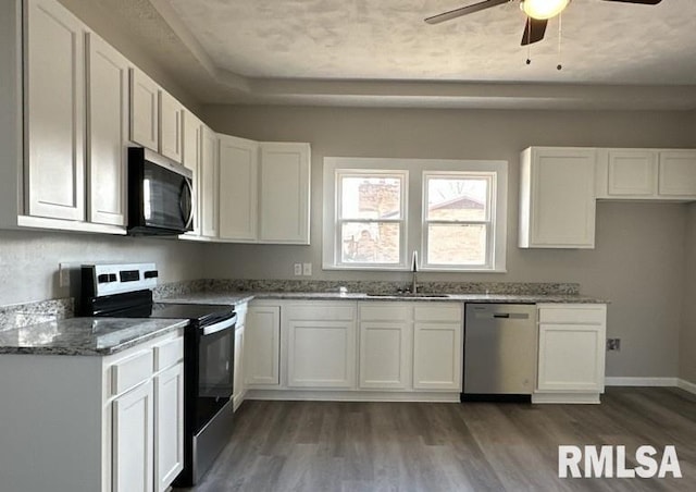 kitchen featuring sink, white cabinetry, dark hardwood / wood-style flooring, stone counters, and stainless steel appliances