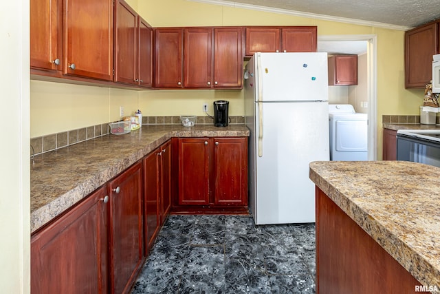 kitchen featuring white appliances, washer / dryer, and vaulted ceiling