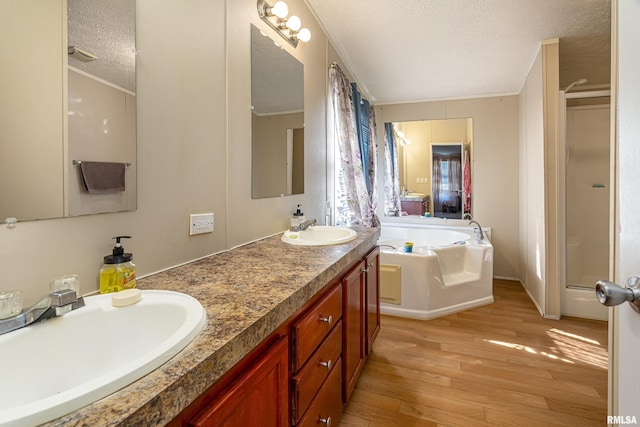 bathroom with crown molding, a bathing tub, hardwood / wood-style floors, and a textured ceiling