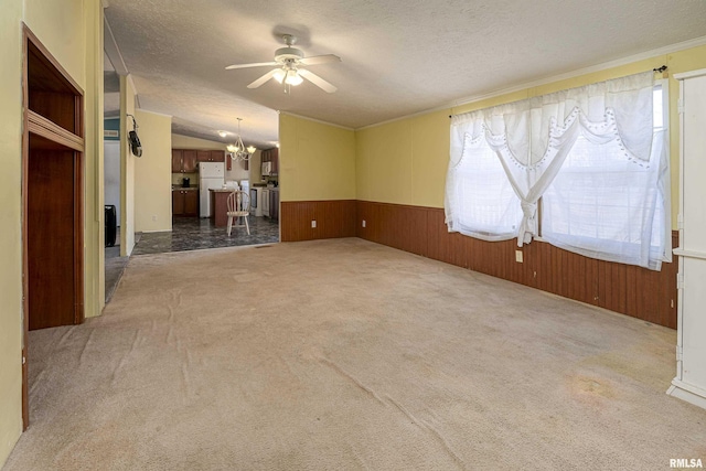 spare room with ceiling fan with notable chandelier, carpet floors, a textured ceiling, and vaulted ceiling