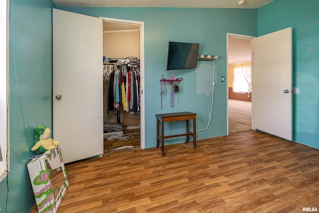 bedroom with vaulted ceiling, a spacious closet, hardwood / wood-style floors, and a closet