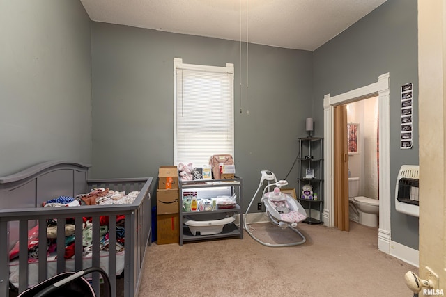 bedroom featuring connected bathroom, carpet floors, and heating unit