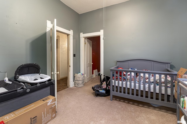 carpeted bedroom featuring a crib