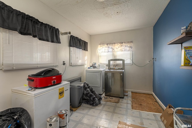 washroom featuring washing machine and dryer and a textured ceiling