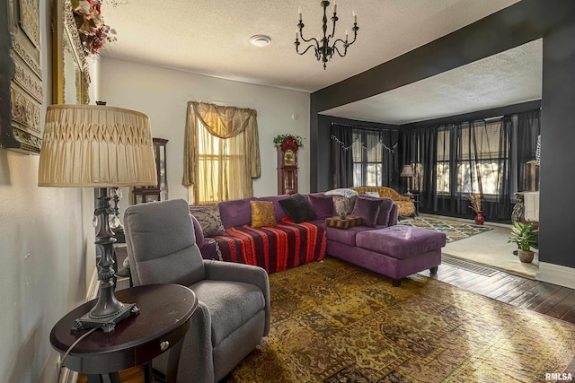 living room with dark hardwood / wood-style floors, a chandelier, and a textured ceiling