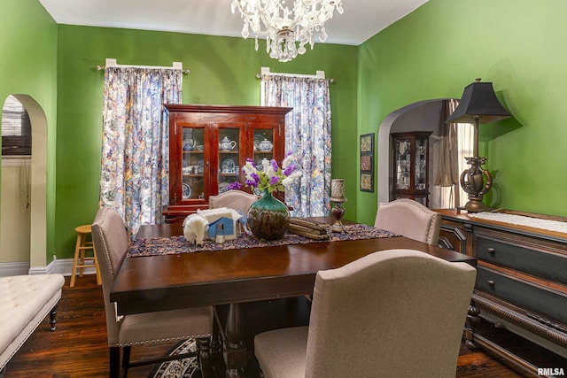 dining space featuring dark wood-type flooring and a chandelier