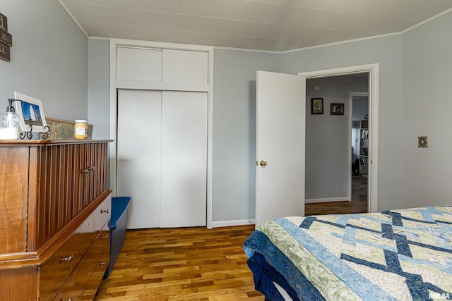 bedroom featuring crown molding, light hardwood / wood-style floors, and a closet