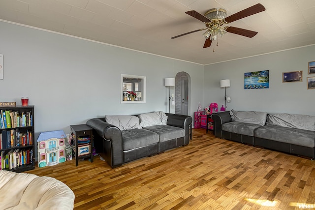 living room featuring ceiling fan, crown molding, and light wood-type flooring