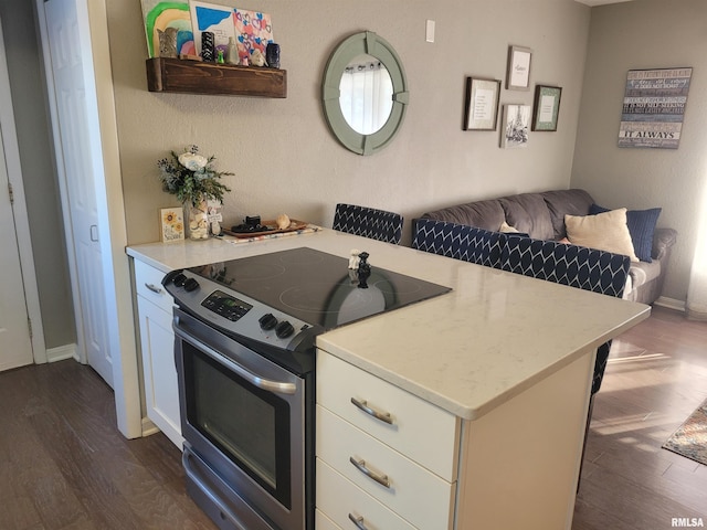 kitchen with dark wood-type flooring, open floor plan, white cabinets, and stainless steel electric range