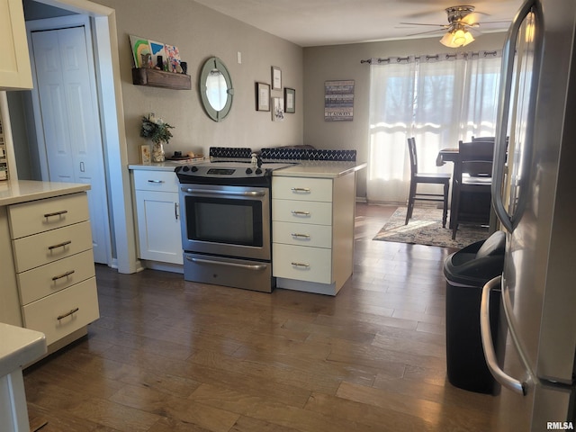 kitchen with stainless steel appliances, light countertops, a ceiling fan, and dark wood finished floors