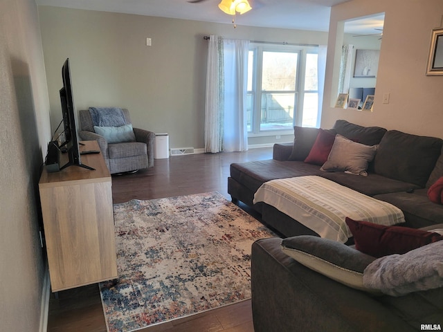 living room featuring ceiling fan and dark hardwood / wood-style flooring