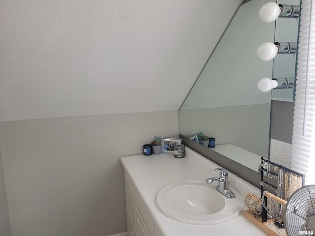 bathroom featuring lofted ceiling and vanity