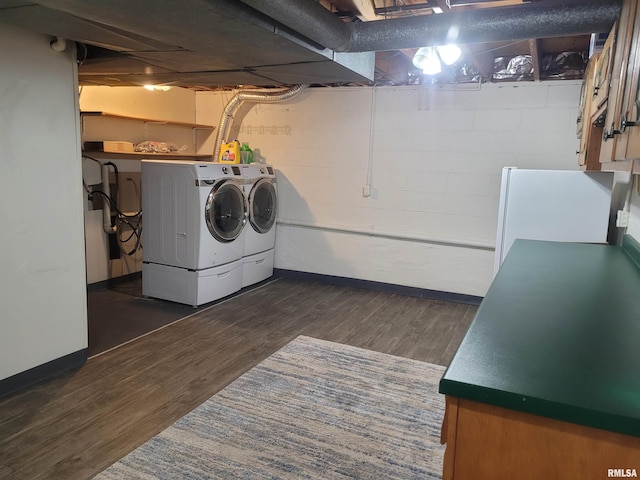 laundry area with dark hardwood / wood-style floors and washing machine and dryer