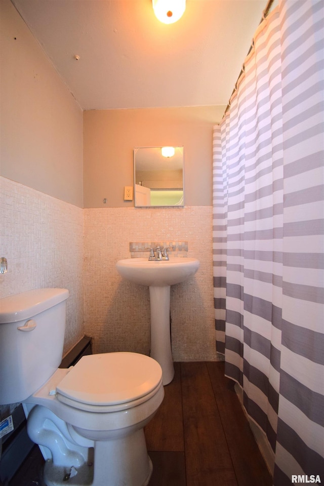 bathroom with wood-type flooring, toilet, and tile walls