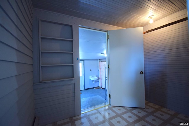 hallway featuring wood ceiling and wood walls