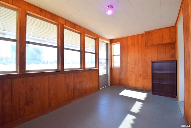 spare room with wood walls