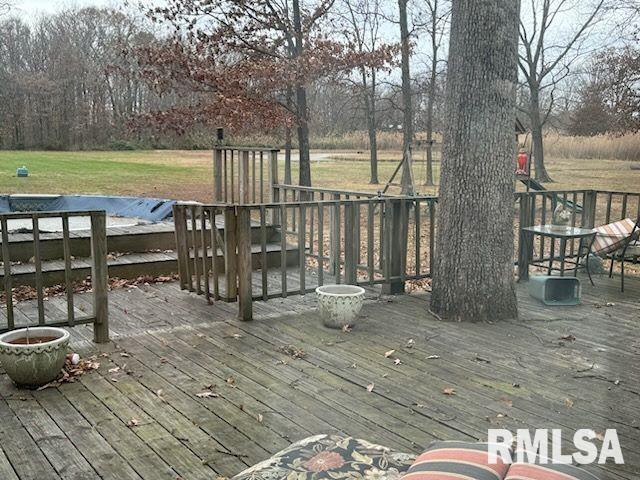 wooden deck featuring a lawn