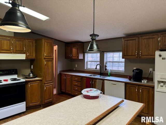 kitchen featuring sink, hanging light fixtures, a textured ceiling, dark hardwood / wood-style flooring, and white appliances