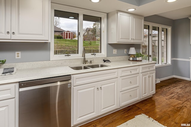 kitchen featuring dishwasher, sink, white cabinets, dark hardwood / wood-style flooring, and light stone countertops