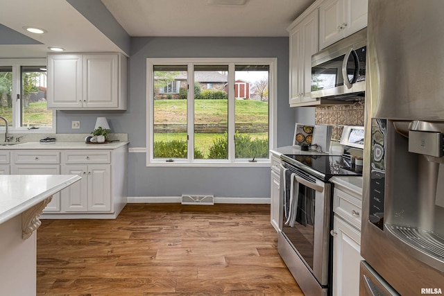 kitchen featuring white cabinetry, a wealth of natural light, and appliances with stainless steel finishes