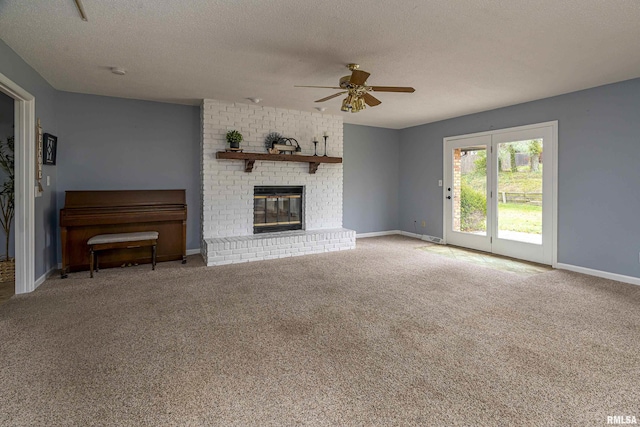 unfurnished living room featuring ceiling fan, a fireplace, carpet, and a textured ceiling