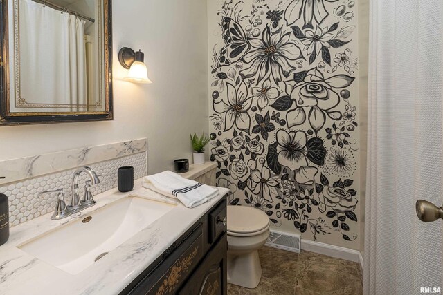 bathroom with vanity, tile patterned flooring, decorative backsplash, and toilet