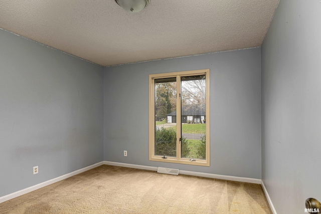 carpeted spare room featuring a textured ceiling