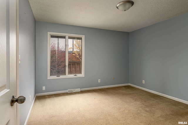 carpeted empty room with a textured ceiling