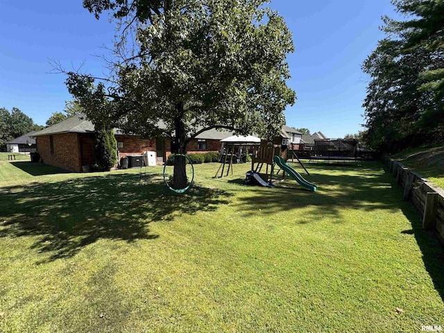 view of yard with a playground and a trampoline