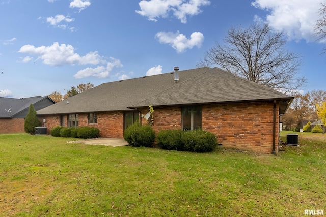 rear view of house with central AC, a lawn, and a patio area