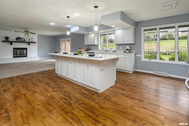 kitchen with white cabinetry, decorative light fixtures, and a kitchen island