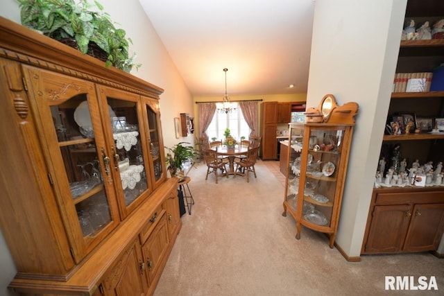 carpeted dining room featuring vaulted ceiling and a notable chandelier