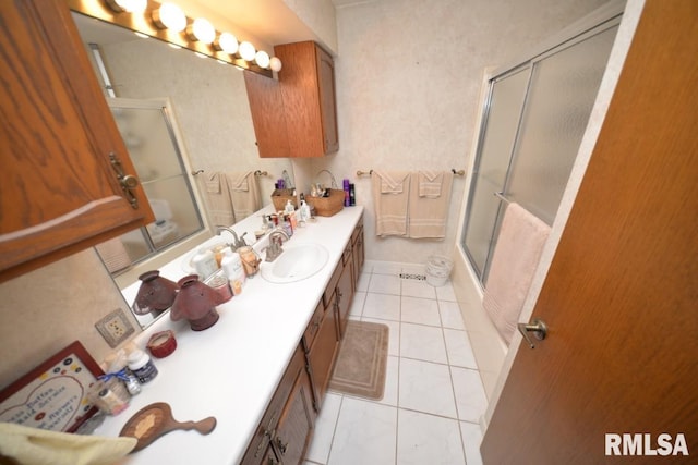 bathroom featuring tile patterned flooring, vanity, and combined bath / shower with glass door