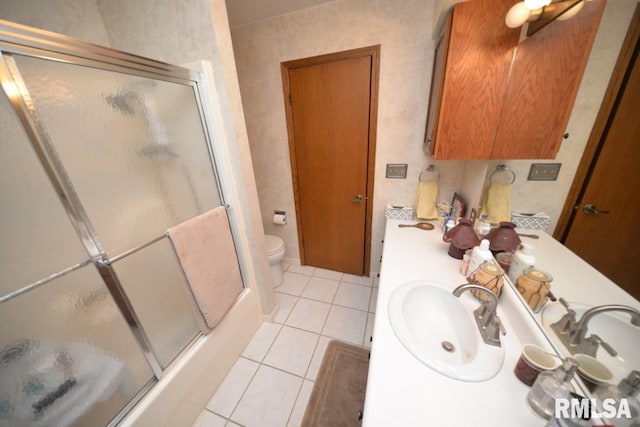 full bathroom with enclosed tub / shower combo, vanity, tile patterned floors, and toilet