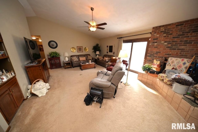 living room featuring a tiled fireplace, lofted ceiling, light colored carpet, and ceiling fan