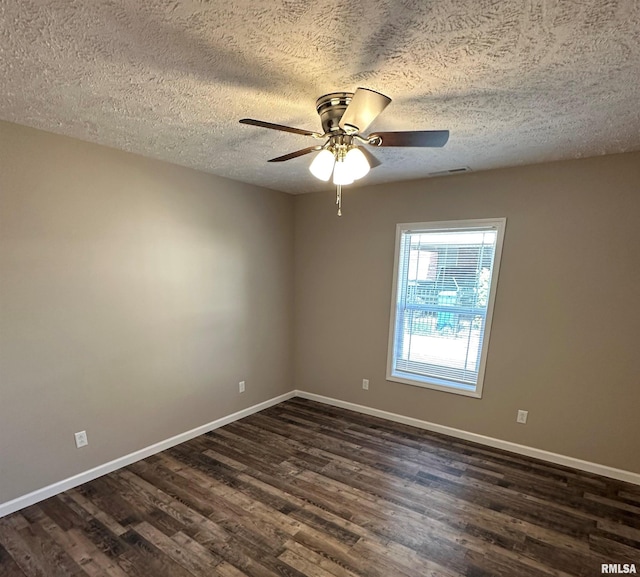 spare room featuring ceiling fan, dark wood-type flooring, and a textured ceiling