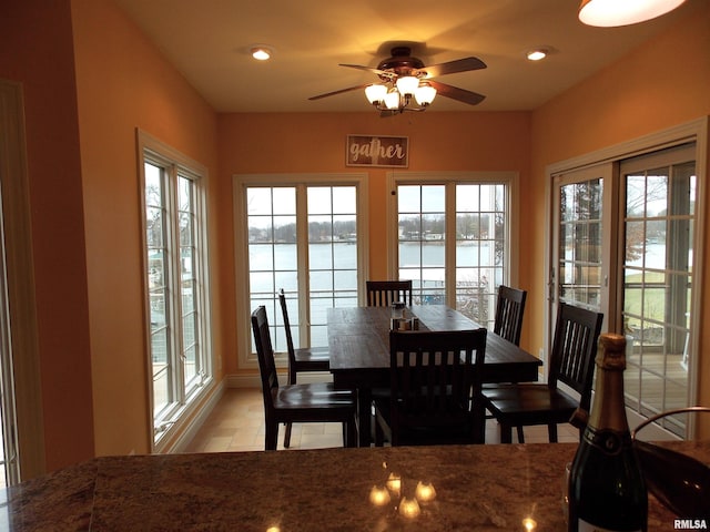 dining room featuring a water view and ceiling fan