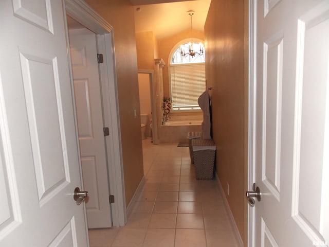 corridor featuring a chandelier and light tile patterned floors