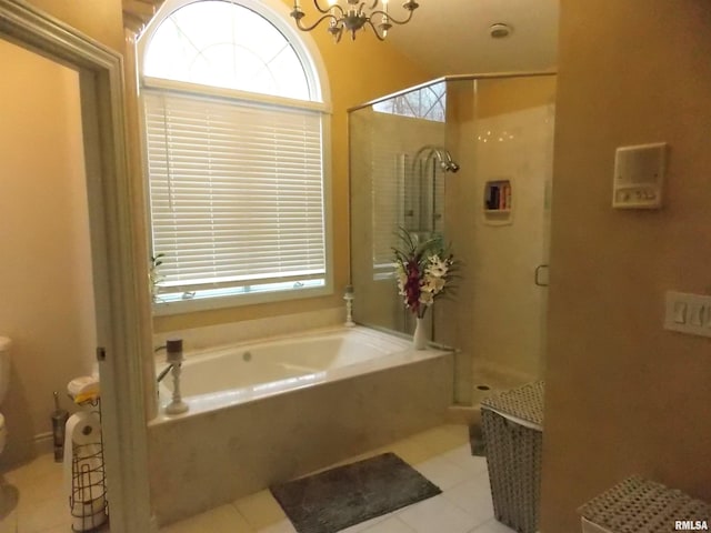 bathroom with tile patterned flooring, shower with separate bathtub, and a notable chandelier