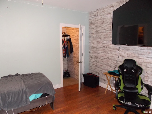 bedroom featuring a spacious closet, hardwood / wood-style floors, and a closet