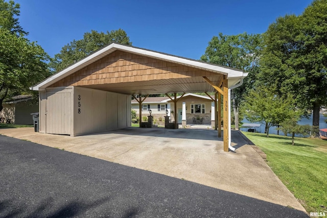 view of parking / parking lot featuring a carport and a lawn