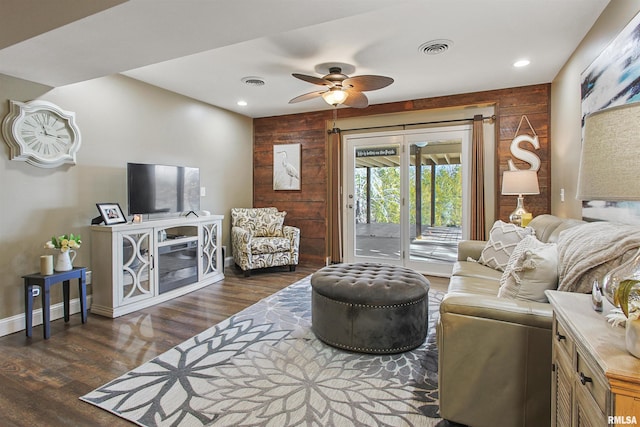 living room with wooden walls, dark hardwood / wood-style floors, and ceiling fan