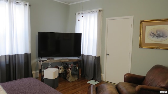 living room featuring dark wood-type flooring, ornamental molding, and a healthy amount of sunlight