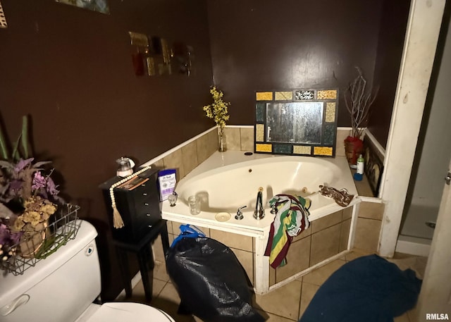 bathroom with tile patterned flooring, tiled bath, and toilet