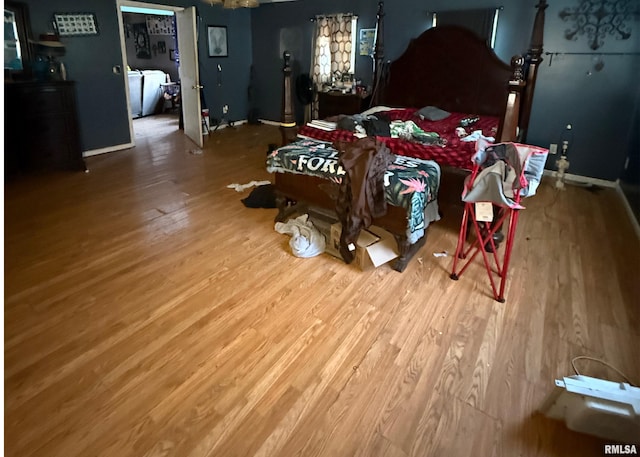 bedroom with hardwood / wood-style flooring and washer and dryer