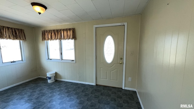 foyer entrance featuring wood walls