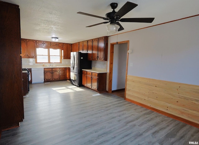 kitchen with white dishwasher, stainless steel fridge, light hardwood / wood-style floors, and ceiling fan