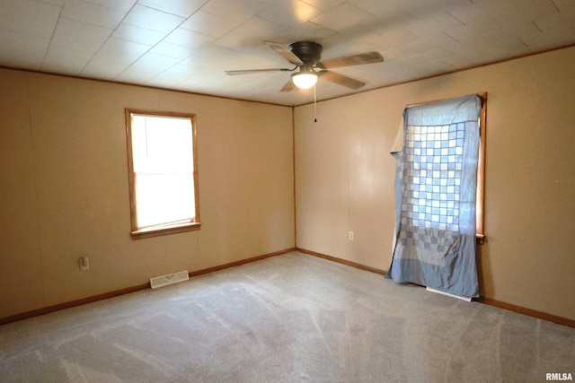 spare room featuring crown molding, ceiling fan, and light carpet